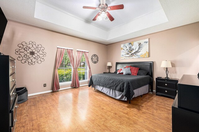 2227 Country Creek Way, Richmond, TX 77406 - bedroom featuring a raised ceiling, light wood-style floors, crown molding, and a ceiling fan