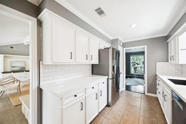 10610 Bordley Dr, Houston, TX 77042 - kitchen with stainless steel appliances, light countertops, light tile patterned floors, white cabinets, and decorative backsplash