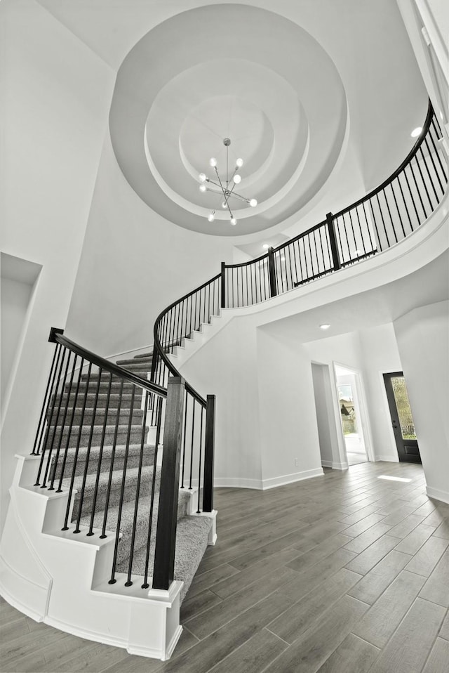 5029 Steady Breeze Dr, Katy, TX 77493 - stairs featuring a towering ceiling, wood finished floors, a chandelier, and a raised ceiling