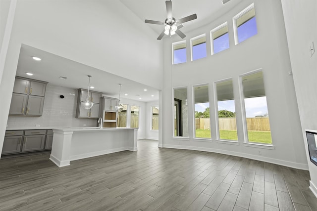 5029 Steady Breeze Dr, Katy, TX 77493 - unfurnished living room featuring plenty of natural light, ceiling fan, a towering ceiling, dark wood-type flooring, and recessed lighting