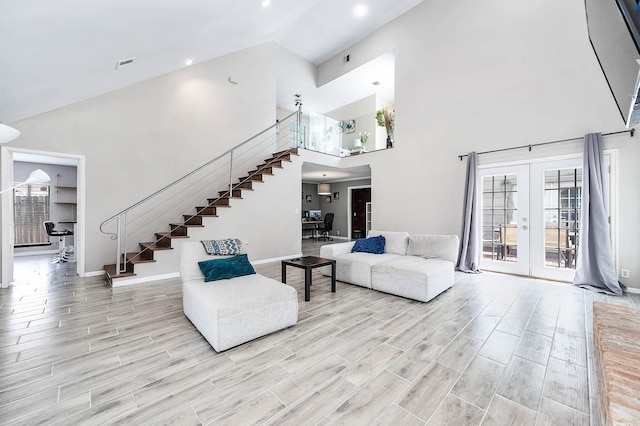 12710 Ashford Pine Dr, Houston, TX 77082 - living room with stairway, high vaulted ceiling, light wood finished floors, and french doors