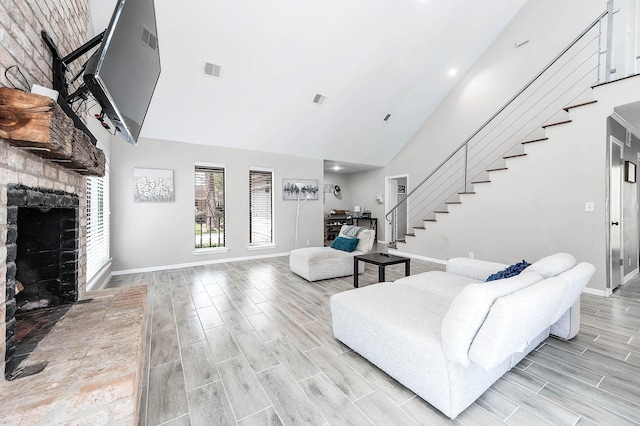 12710 Ashford Pine Dr, Houston, TX 77082 - living room with high vaulted ceiling, stairs, a fireplace, and wood tiled floors