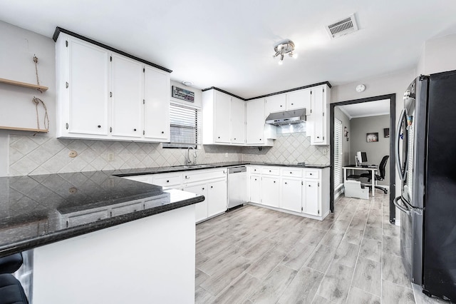 12710 Ashford Pine Dr, Houston, TX 77082 - kitchen with appliances with stainless steel finishes, under cabinet range hood, a peninsula, decorative backsplash, and dark stone countertops