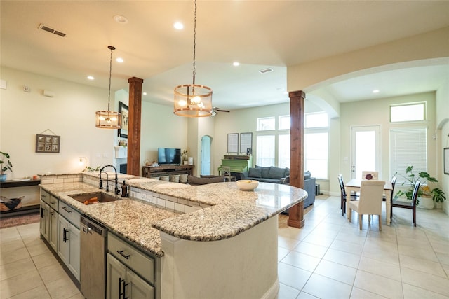 29622 Pewter Run Ln, Katy, TX 77494 - kitchen with stainless steel dishwasher, arched walkways, recessed lighting, light tile patterned floors, and decorative columns