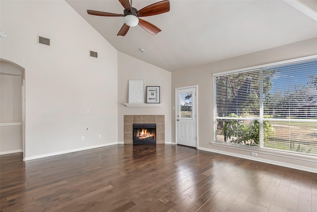19002 Volley Vale Ct, Humble, TX 77346 - unfurnished living room featuring high vaulted ceiling, a ceiling fan, arched walkways, wood finished floors, and a tiled fireplace
