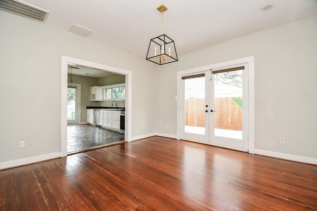 90 Dennis St, Houston, TX 77006 - spare room with a chandelier, dark wood-type flooring, and french doors