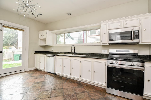 90 Dennis St, Houston, TX 77006 - kitchen with appliances with stainless steel finishes, healthy amount of natural light, and white cabinetry