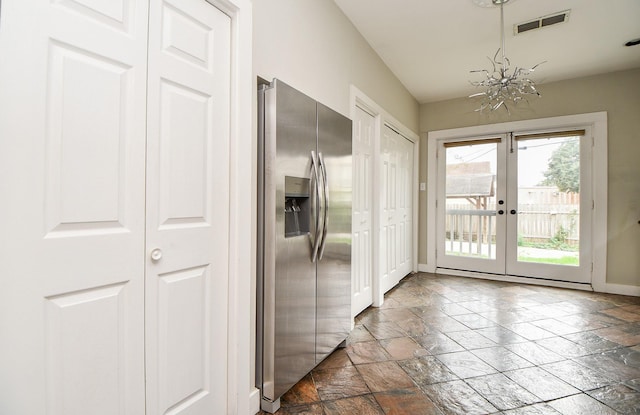 90 Dennis St, Houston, TX 77006 - doorway to outside featuring french doors, stone tile floors, and a chandelier