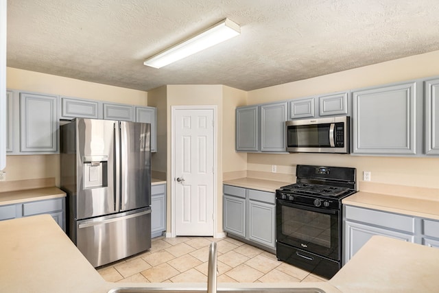 3434 Fiorella Way, Humble, TX 77338 - kitchen with stainless steel appliances, gray cabinetry, light countertops, light tile patterned floors, and a textured ceiling