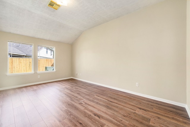 3434 Fiorella Way, Humble, TX 77338 - unfurnished room featuring vaulted ceiling, wood finished floors, and a textured ceiling