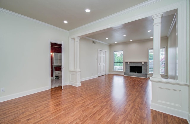 5701 Winsome Ln Unit 2, Houston, TX 77057 - unfurnished living room featuring decorative columns, ornamental molding, light wood-style flooring, recessed lighting, and a high end fireplace