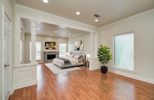5701 Winsome Ln Unit 2, Houston, TX 77057 - living area featuring decorative columns, wood finished floors, a fireplace with raised hearth, crown molding, and recessed lighting