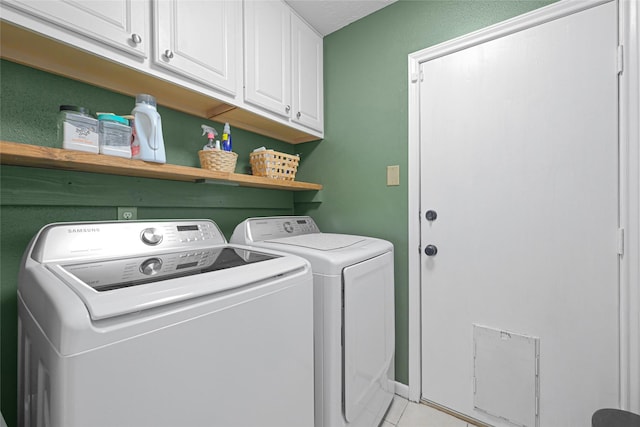 12814 Westmere Dr, Houston, TX 77077 - washroom with washing machine and clothes dryer, cabinet space, and light tile patterned floors