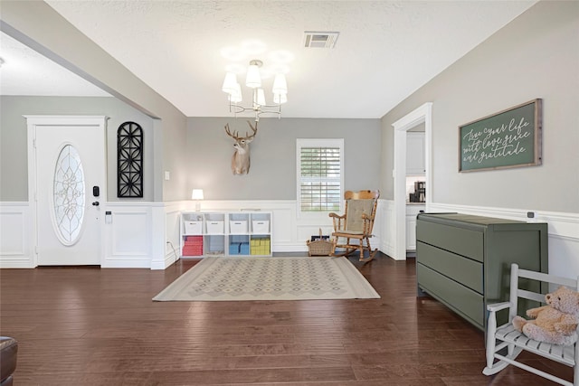 12814 Westmere Dr, Houston, TX 77077 - entryway with a wainscoted wall, a chandelier, a decorative wall, and dark wood-type flooring