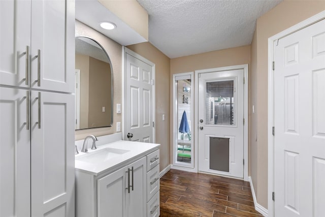 627 S Hyannis Port St, Crosby, TX 77532 - bathroom with vanity, wood finished floors, and a textured ceiling