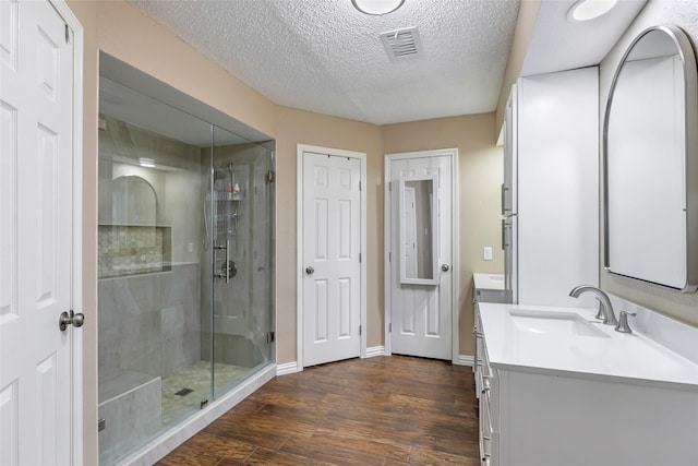 627 S Hyannis Port St, Crosby, TX 77532 - bathroom featuring vanity, a stall shower, wood finished floors, and a textured ceiling