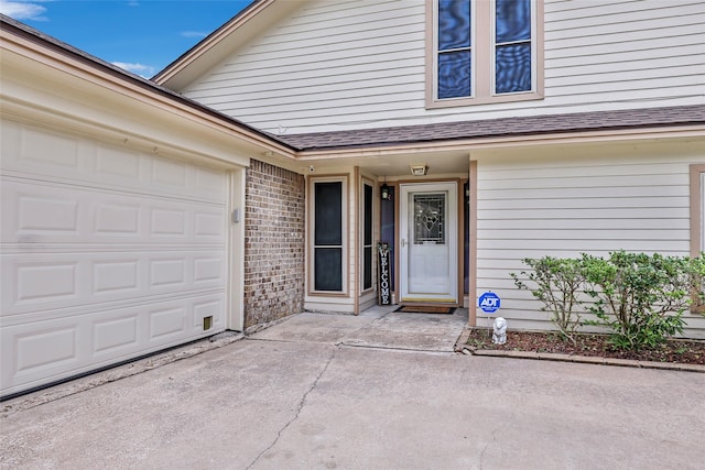 627 S Hyannis Port St, Crosby, TX 77532 - view of exterior entry featuring a garage, roof with shingles, concrete driveway, and brick siding