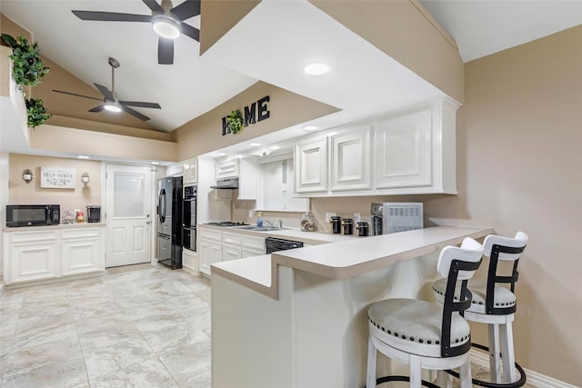 627 S Hyannis Port St, Crosby, TX 77532 - kitchen with vaulted ceiling, a ceiling fan, a peninsula, a breakfast bar, and light countertops