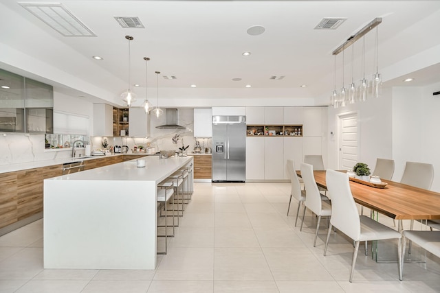 8911 Birdwood Ct, Houston, TX 77096 - kitchen with appliances with stainless steel finishes, modern cabinets, wall chimney range hood, a large island, and white cabinets