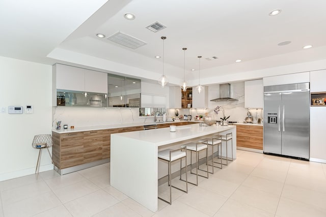 8911 Birdwood Ct, Houston, TX 77096 - kitchen with stainless steel appliances, modern cabinets, wall chimney exhaust hood, a kitchen breakfast bar, and decorative backsplash