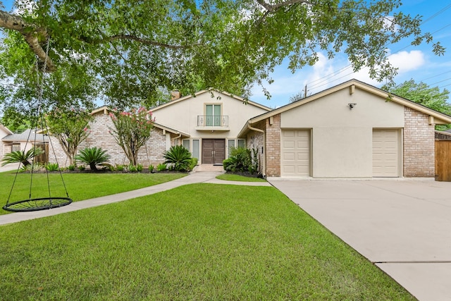8911 Birdwood Ct, Houston, TX 77096 - view of front of property featuring concrete driveway, a front yard, an attached garage, stucco siding, and brick siding