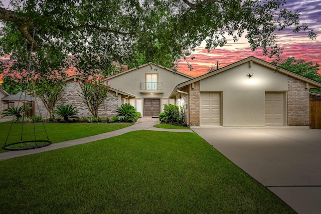 8911 Birdwood Ct, Houston, TX 77096 - view of front of property with concrete driveway, a lawn, stucco siding, and brick siding