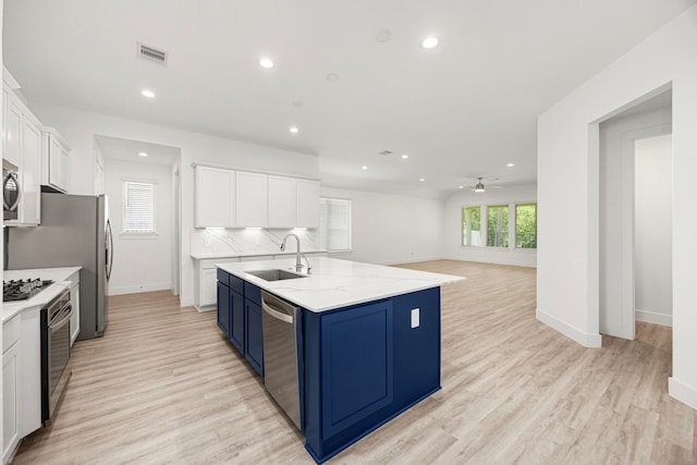 15308 Sandhill Crane Ln, Conroe, TX 77384 - kitchen with stainless steel appliances, blue cabinets, recessed lighting, white cabinets, and a ceiling fan