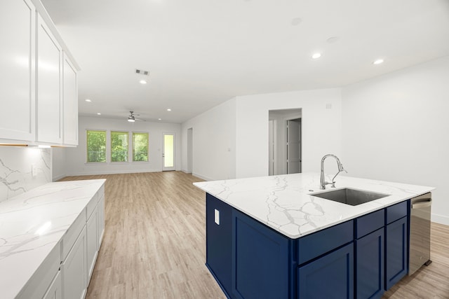 15308 Sandhill Crane Ln, Conroe, TX 77384 - kitchen with light wood finished floors, white cabinets, recessed lighting, a kitchen island with sink, and blue cabinetry