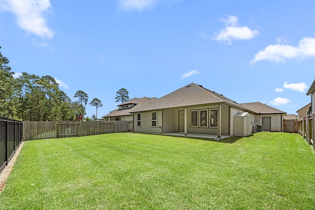 15308 Sandhill Crane Ln, Conroe, TX 77384 - back of house with a fenced backyard, a patio, a storage shed, and roof with shingles