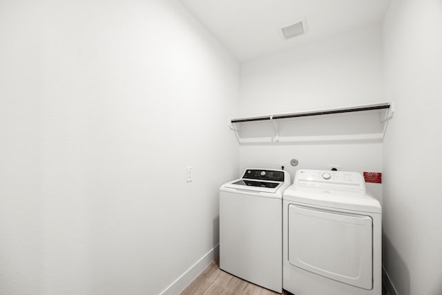 15308 Sandhill Crane Ln, Conroe, TX 77384 - laundry area with light wood-style floors and washer and dryer