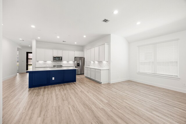 15308 Sandhill Crane Ln, Conroe, TX 77384 - kitchen featuring appliances with stainless steel finishes, backsplash, recessed lighting, light wood-type flooring, and light countertops