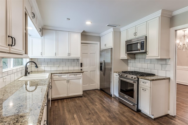 5541 Schumacher Ln, Houston, TX 77056 - kitchen featuring appliances with stainless steel finishes, white cabinetry, dark wood-style flooring, crown molding, and light stone counters