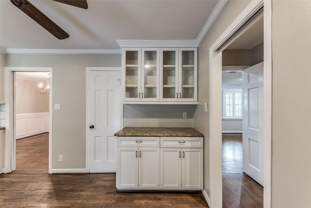 5541 Schumacher Ln, Houston, TX 77056 - kitchen featuring ornamental molding, dark wood-style floors, glass insert cabinets, dark stone countertops, and white cabinets