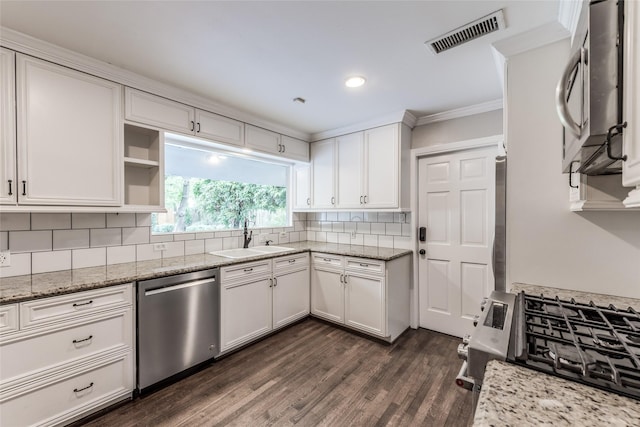 5541 Schumacher Ln, Houston, TX 77056 - kitchen with stainless steel appliances, white cabinets, backsplash, dark wood-style flooring, and ornamental molding