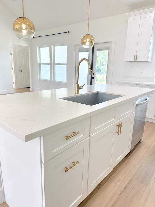 1310 Denson Allen, Coldspring, TX 77331 - kitchen featuring light wood-type flooring, dishwasher, hanging light fixtures, and white cabinetry