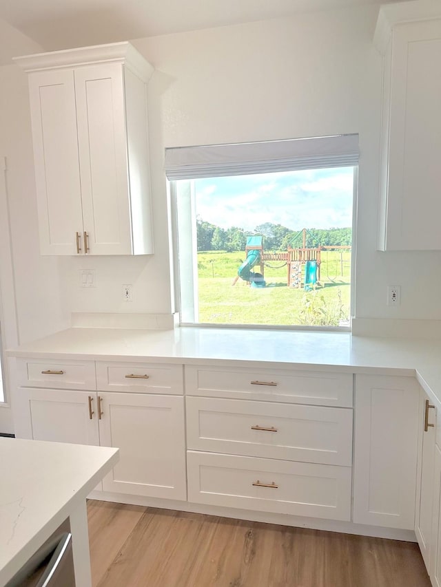 1310 Denson Allen, Coldspring, TX 77331 - kitchen featuring white cabinets, light countertops, healthy amount of natural light, and light wood-type flooring