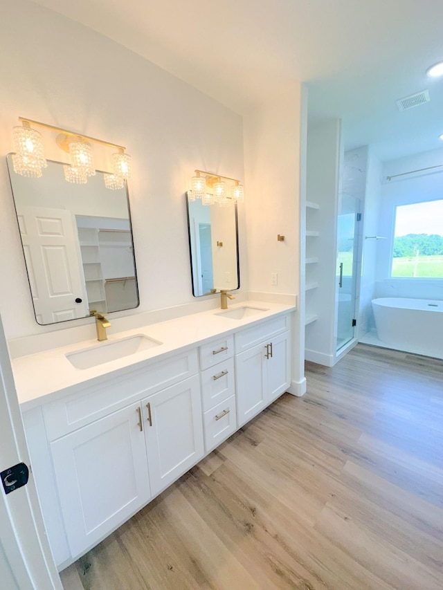 1310 Denson Allen, Coldspring, TX 77331 - bathroom with wood finished floors, double vanity, a freestanding bath, and a stall shower