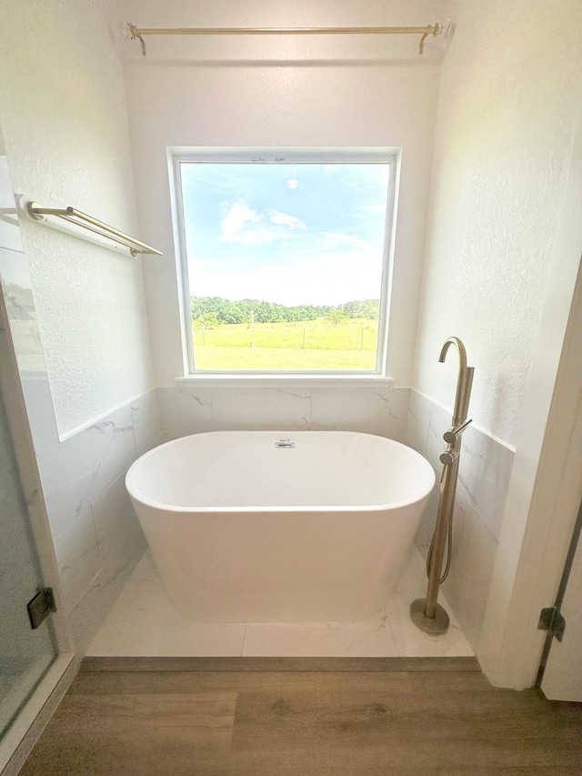 1310 Denson Allen, Coldspring, TX 77331 - bathroom featuring wood finished floors, a freestanding tub, and plenty of natural light