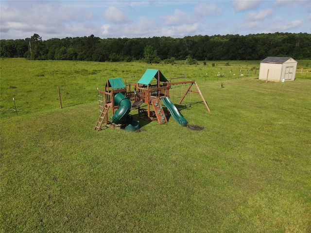 1310 Denson Allen, Coldspring, TX 77331 - view of play area featuring a shed, a yard, a view of countryside, and a view of trees