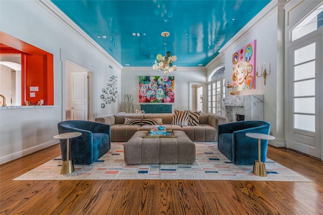 1069 Kirby Dr, Houston, TX 77019 - living room featuring crown molding, wood-type flooring, a chandelier, healthy amount of natural light, and a premium fireplace