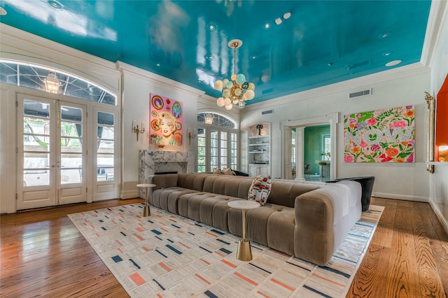 1069 Kirby Dr, Houston, TX 77019 - living room with french doors, crown molding, wood finished floors, a premium fireplace, and a chandelier