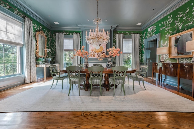1069 Kirby Dr, Houston, TX 77019 - dining room featuring a chandelier, wallpapered walls, ornamental molding, plenty of natural light, and wood finished floors