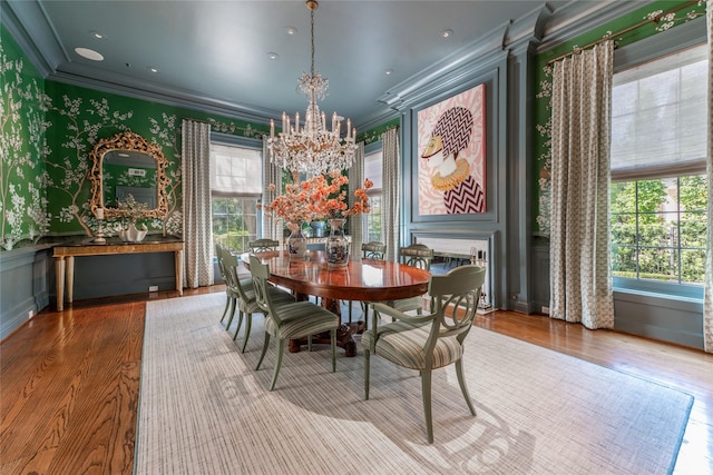 1069 Kirby Dr, Houston, TX 77019 - dining space featuring ornamental molding, a chandelier, wood finished floors, and wallpapered walls