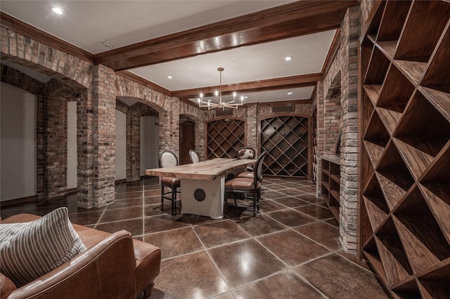 1069 Kirby Dr, Houston, TX 77019 - wine room with arched walkways, a chandelier, beam ceiling, crown molding, and brick wall