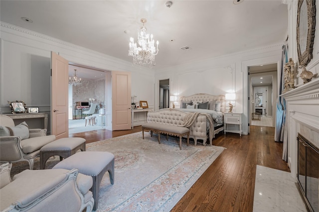 1069 Kirby Dr, Houston, TX 77019 - bedroom with a chandelier, dark wood finished floors, ornamental molding, and a tile fireplace