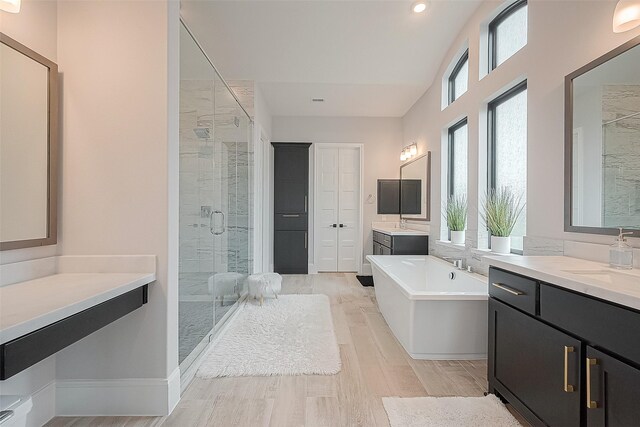 2201 Mulberry Ridge Ct, Manvel, TX 77578 - bathroom featuring a stall shower, two vanities, a freestanding bath, wood finished floors, and recessed lighting