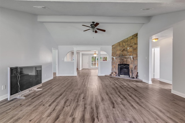 1602 Evesham Dr, Houston, TX 77015 - unfurnished living room with a stone fireplace, ceiling fan, beamed ceiling, wood finished floors, and arched walkways