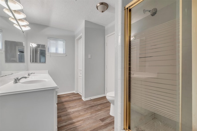 1602 Evesham Dr, Houston, TX 77015 - bathroom with double vanity, wood finished floors, a shower stall, and a textured ceiling