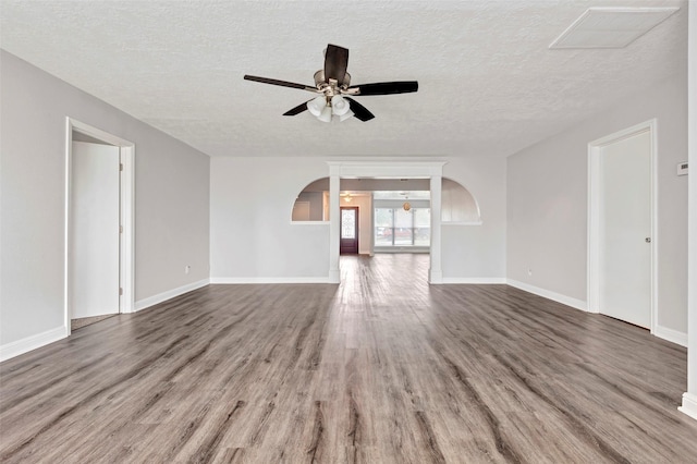 1602 Evesham Dr, Houston, TX 77015 - unfurnished living room featuring arched walkways, a ceiling fan, wood finished floors, and a textured ceiling