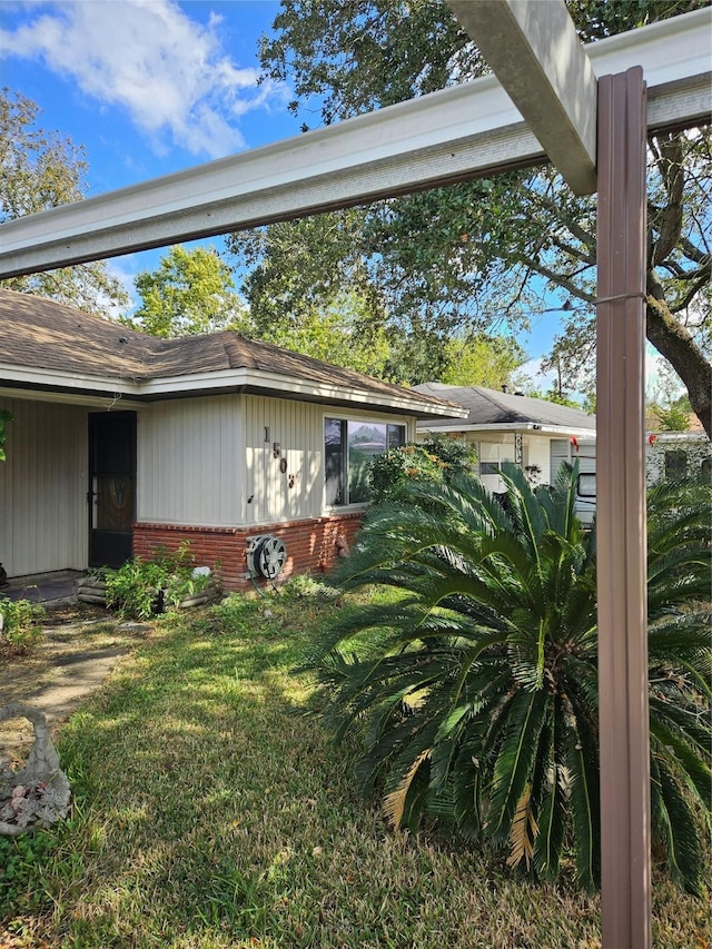 1503 Beusch Dr, Pasadena, TX 77502 - view of side of property featuring brick siding, a lawn, and roof with shingles
